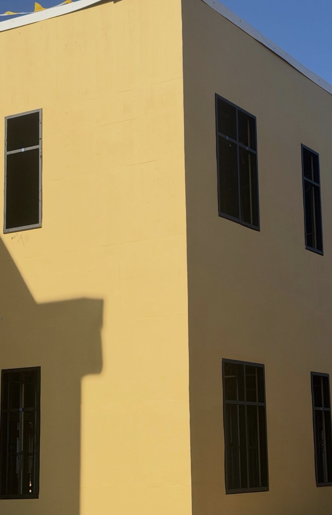 Corner elevation with grid-pattern windows on second floor