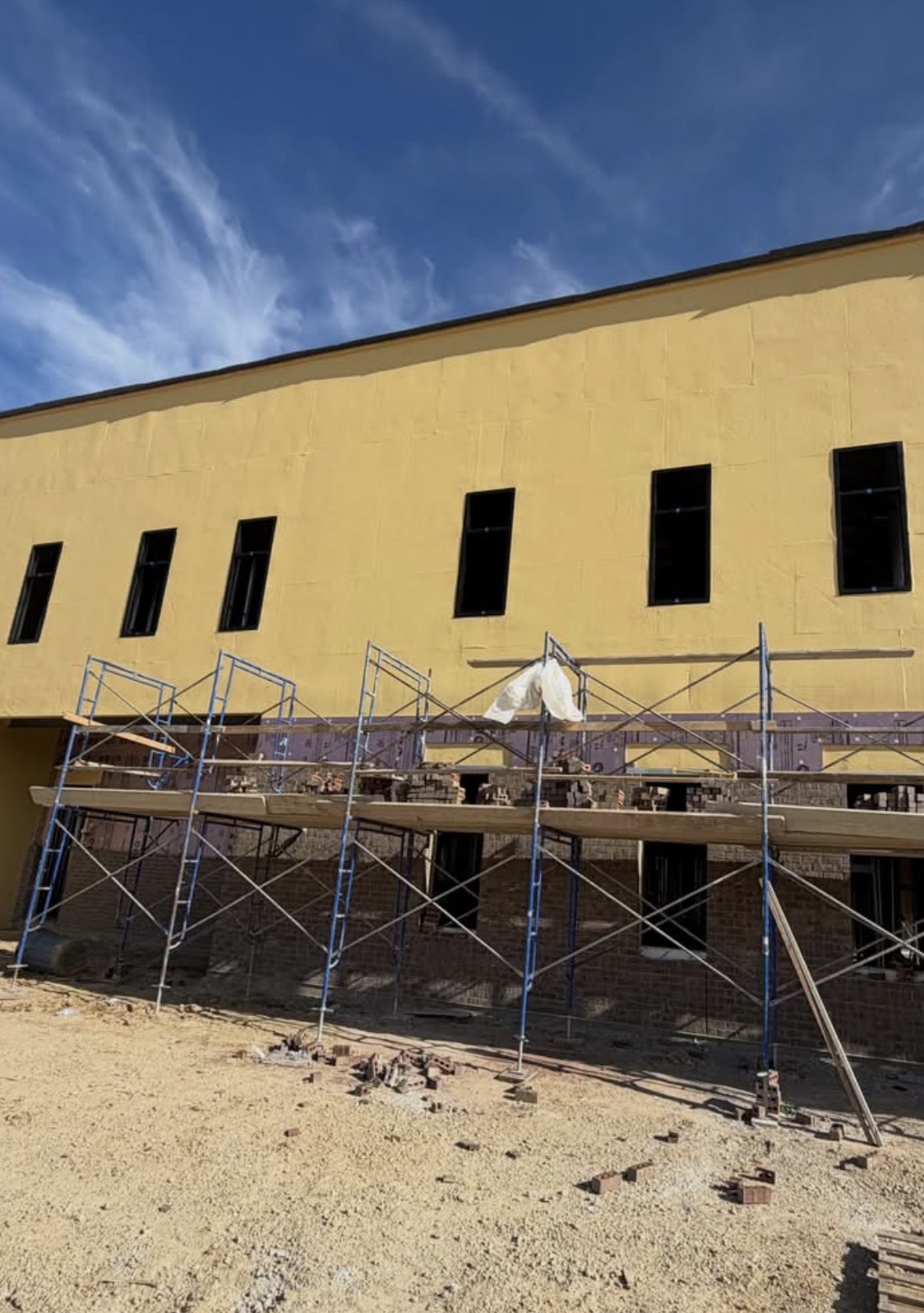 Field of punched windows installed ahead of brick veneer